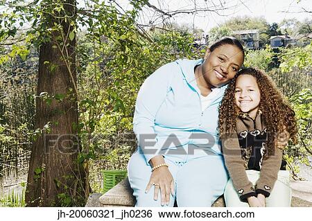 African mother and daughter hugging and smiling outdoors View Large Photo Image Stock Photograph - African mother and daughter hugging and smiling outdoors. Fotosearch