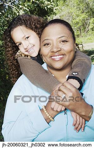 African mother and daughter hugging outdoors View Large Photo Image Stock Image - African mother and daughter hugging outdoors. Fotosearch