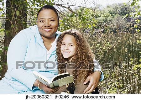 African mother and daughter reading outdoors View Large Photo Image Stock Photograph - African mother and daughter reading outdoors. Fotosearch