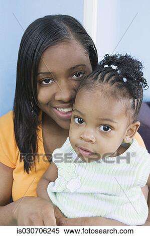 Stock Photography - African mother hugging young daughter. Fotosearch