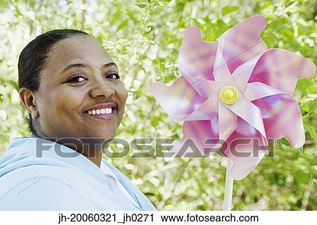 African woman holding pinwheel outdoors View Large Photo Image Stock Image - African woman holding pinwheel outdoors. Fotosearch