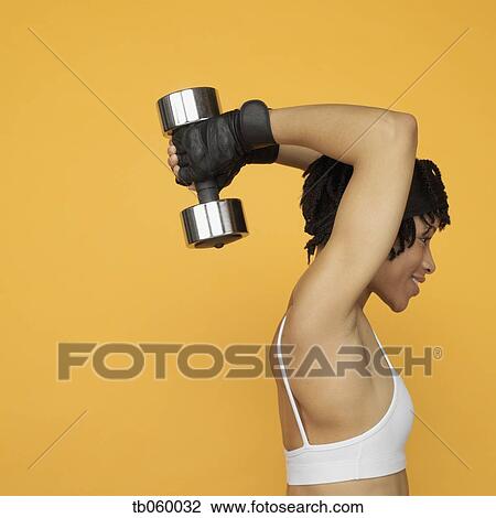 Stock Image - African woman lifting weights. Fotosearch