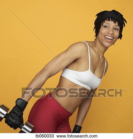 Stock Image - African woman lifting weights. Fotosearch