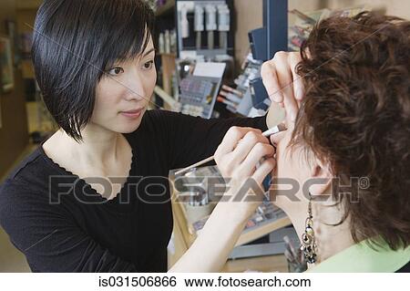 Asian female make up artist performing make over in salon View Large Photo Image Stock Photograph - Asian female make up artist performing make over in salon. Fotosearch