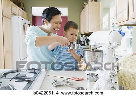 Asian mother and young son baking in kitchen View Large Photo Image Picture - Asian mother and young son baking in kitchen. Fotosearch