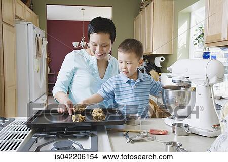 Asian mother and young son making cookies View Large Photo Image Picture - Asian mother and young son making cookies. Fotosearch