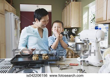 Stock Photograph - Asian mother and young son making cookies. Fotosearch
