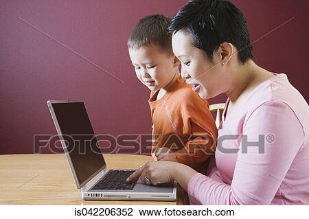 Asian mother and young son using laptop View Large Photo Image Stock Image - Asian mother and young son using laptop. Fotosearch
