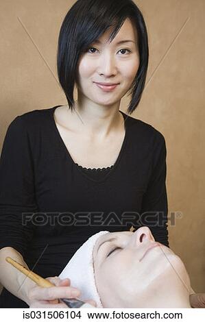 Picture - Asian woman performing spa treatment. Fotosearch