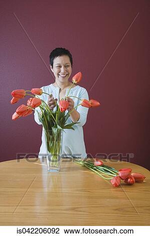 Asian woman putting flowers in vase View Large Photo Image Stock Image - Asian woman putting flowers in vase. Fotosearch