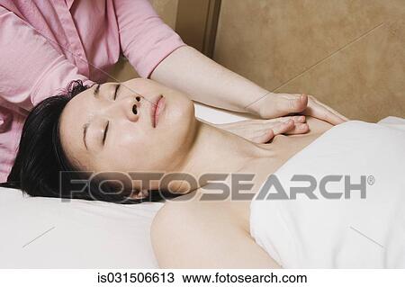 Stock Image - Asian woman receiving massage. Fotosearch