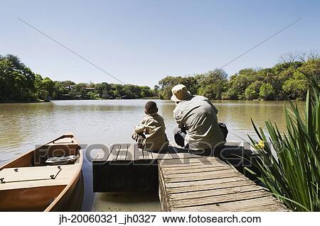 Father and son sitting on dock View Large Photo Image Stock Photo - Father and son sitting on dock. Fotosearch