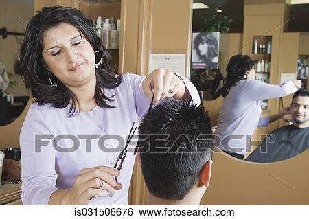 Stock Photograph - Hispanic female hairstylist cutting hair. Fotosearch