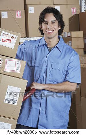 Hispanic male warehouse worker with stack of boxes View Large Photo Image Stock Photography - Hispanic male warehouse worker with stack of boxes. Fotosearch