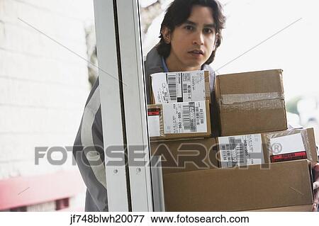 Male delivery person with stack of boxes View Large Photo Image Stock Photo - Male delivery person with stack of boxes. Fotosearch