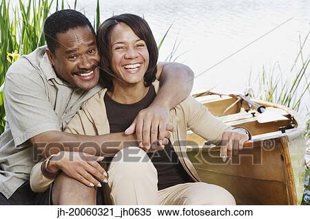 Middle-aged African couple laughing next to canoe View Large Photo Image Stock Photography - Middle-aged African couple laughing next to canoe. Fotosearch