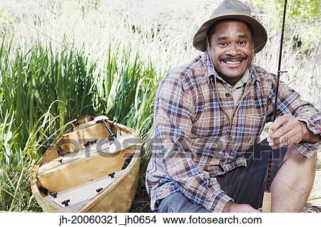 Middle aged African man with fishing gear next to canoe View Large Photo Image Picture - Middle aged African man with fishing gear next to canoe. Fotosearch