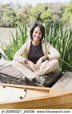 Middle-aged African woman sitting on dock smiling View Large Photo Image Stock Photograph - Middle-aged African woman sitting on dock smiling. Fotosearch