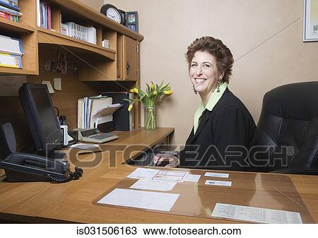 Stock Image - Middle-aged businesswoman at desk. Fotosearch