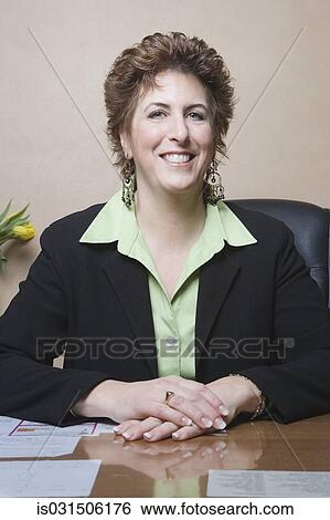 Middle-aged businesswoman at desk View Large Photo Image Stock Photograph - Middle-aged businesswoman at desk. Fotosearch
