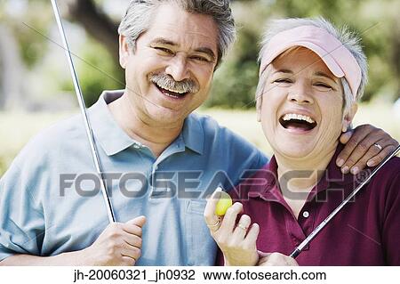 Middle-aged couple laughing with golf clubs View Large Photo Image Stock Image - Middle-aged couple laughing with golf clubs. Fotosearch