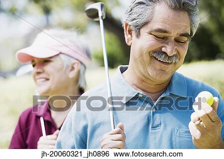 Middle-aged couple with golf clubs View Large Photo Image Stock Photograph - Middle-aged couple with golf clubs. Fotosearch