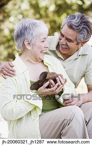 Middle-aged couple with handful of pinecones outdoors View Large Photo Image Stock Photo - Middle-aged couple with handful of pinecones outdoors. Fotosearch