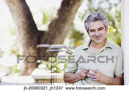 Middle-aged man with coffee smiling outdoors View Large Photo Image Stock Photo - Middle-aged man with coffee smiling outdoors. Fotosearch