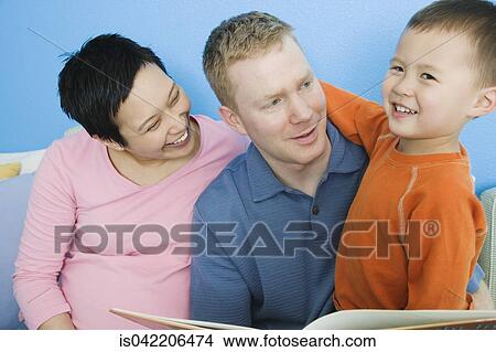 Pregnant parents reading to young son View Large Photo Image Picture - Pregnant parents reading to young son. Fotosearch