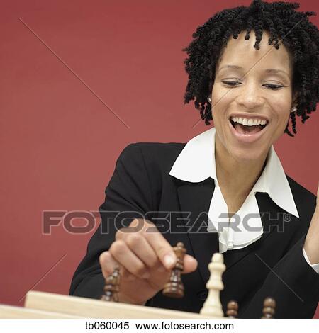 Stock Photography - Studio shot of African woman playing chess. Fotosearch