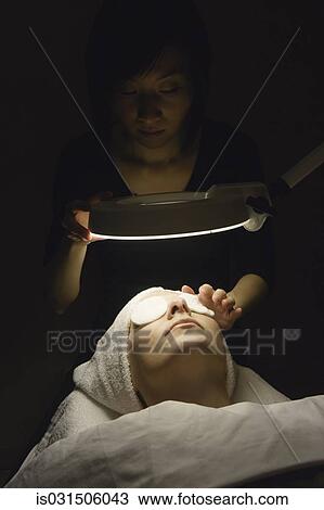 Stock Image - Woman receiving facial at spa. Fotosearch