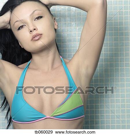 Stock Photo - Woman wearing bathing suit in shower. Fotosearch