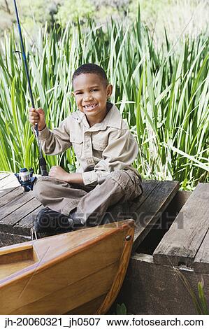 Stock Photo - Young African boy on dock with fishing pole. Fotosearch