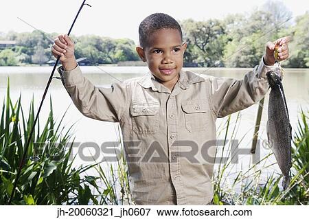 Stock Photo - Young African boy with fishing pole and fish. Fotosearch