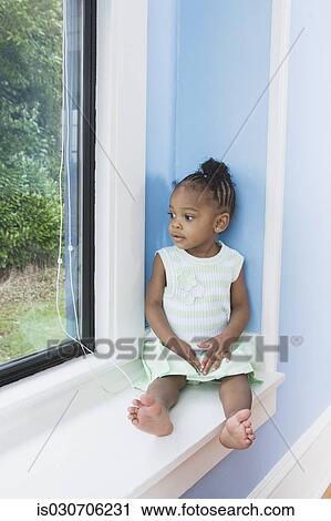 Young African girl sitting in window seat View Large Photo Image Stock Image - Young African girl sitting in window seat. Fotosearch