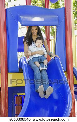 Young African mother on slide with baby on lap View Large Photo Image Stock Image - Young African mother on slide with baby on lap. Fotosearch