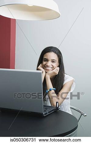 Stock Image - Young African woman using laptop. Fotosearch