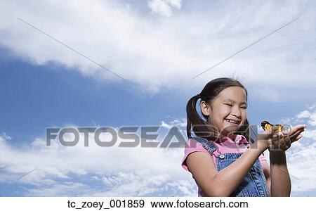 Young Asian girl holding butterfly outdoors View Large Photo Image Stock Photo - Young Asian girl holding butterfly outdoors. Fotosearch