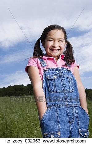 Stock Image - Young Asian girl smiling outdoors. Fotosearch