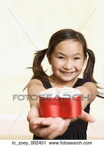 Young Asian girl with heart box in outstretched hands View Large Photo Image Stock Image - Young Asian girl with heart box in outstretched hands. Fotosearch