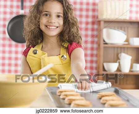 Stock Photo - Young girl baking cookies. Fotosearch