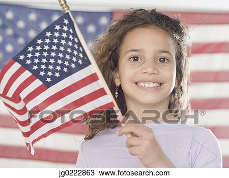 Stock Image - Young girl holding American flag. Fotosearch