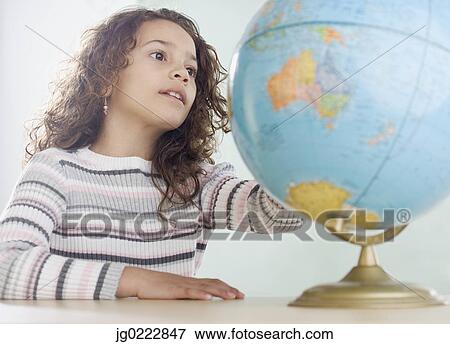 Stock Photo - Young girl looking at globe. Fotosearch