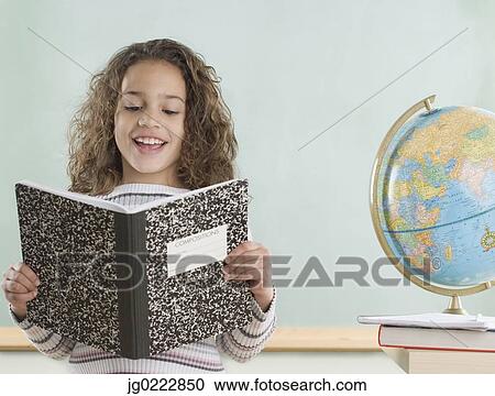 Young girl reading from notebook in classroom View Large Photo Image Stock Image - Young girl reading from notebook in classroom. Fotosearch