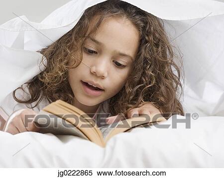 Young girl reading under sheets View Large Photo Image Stock Photography - Young girl reading under sheets. Fotosearch