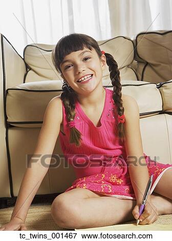 Young girl sitting on floor doing homework View Large Photo Image Stock Photo - Young girl sitting on floor doing homework. Fotosearch
