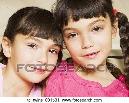 Stock Image - Young Hispanic sisters smiling. Fotosearch