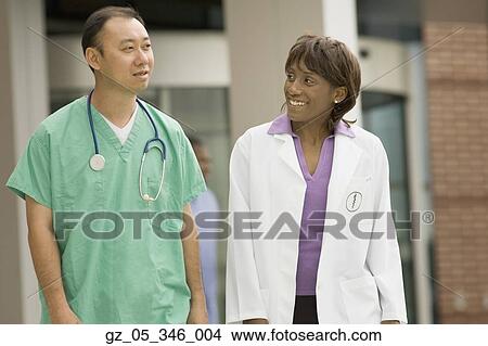 African female doctor and Asian male surgeon talking outdoors View Large Photo Image Picture - African female doctor and Asian male surgeon talking outdoors. Fotosearch