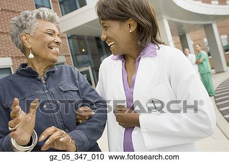African female doctor laughing with senior African woman outdoors View Large Photo Image Stock Image - African female doctor laughing with senior African woman outdoors. Fotosearch