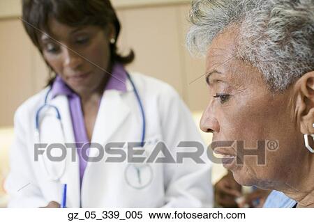 Stock Photography - African female doctor with senior patient. Fotosearch